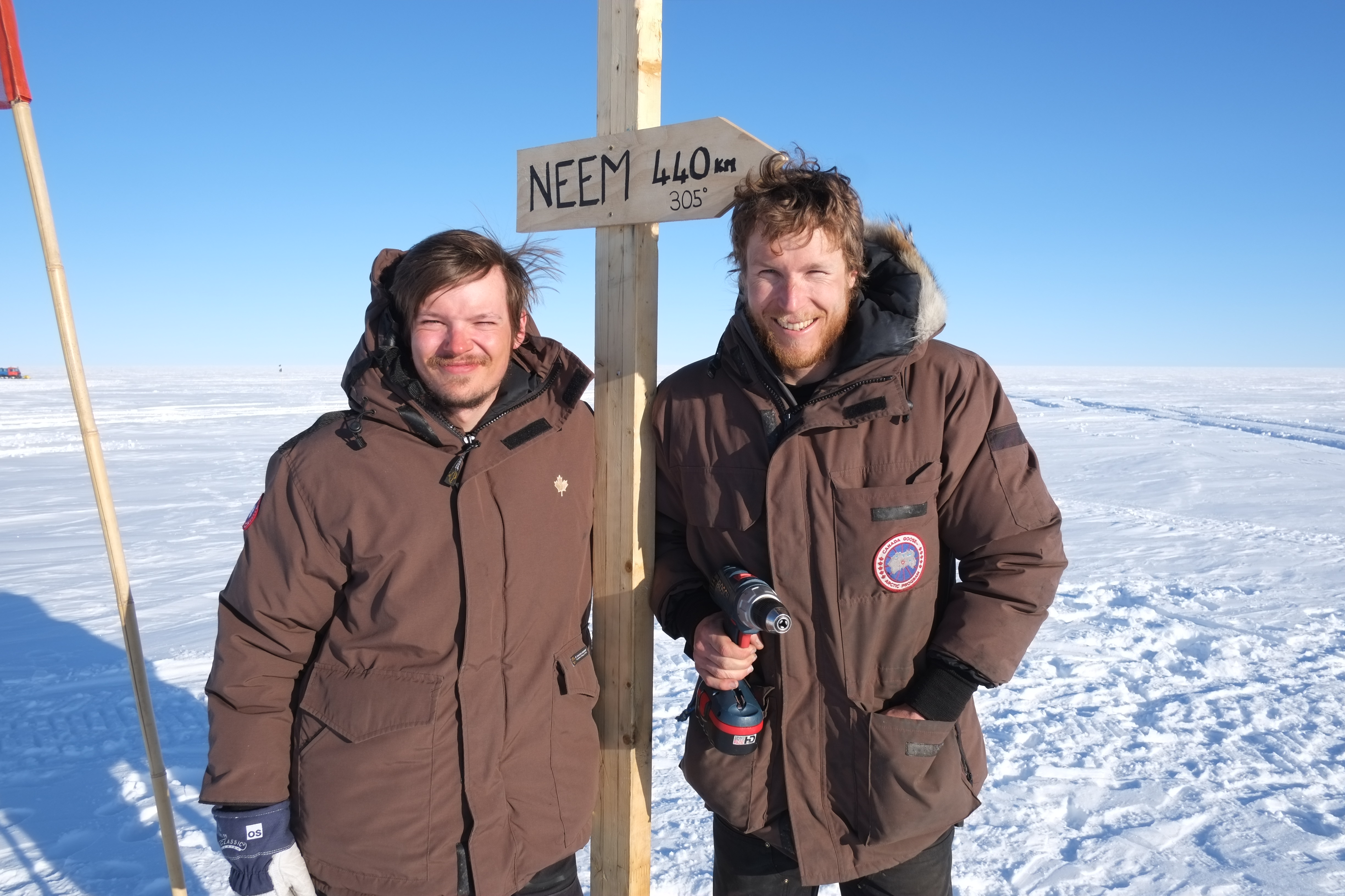 Mathias and Joel at the new road sign in the middle of EGRIP camp. It points to NEEM 440 km away.